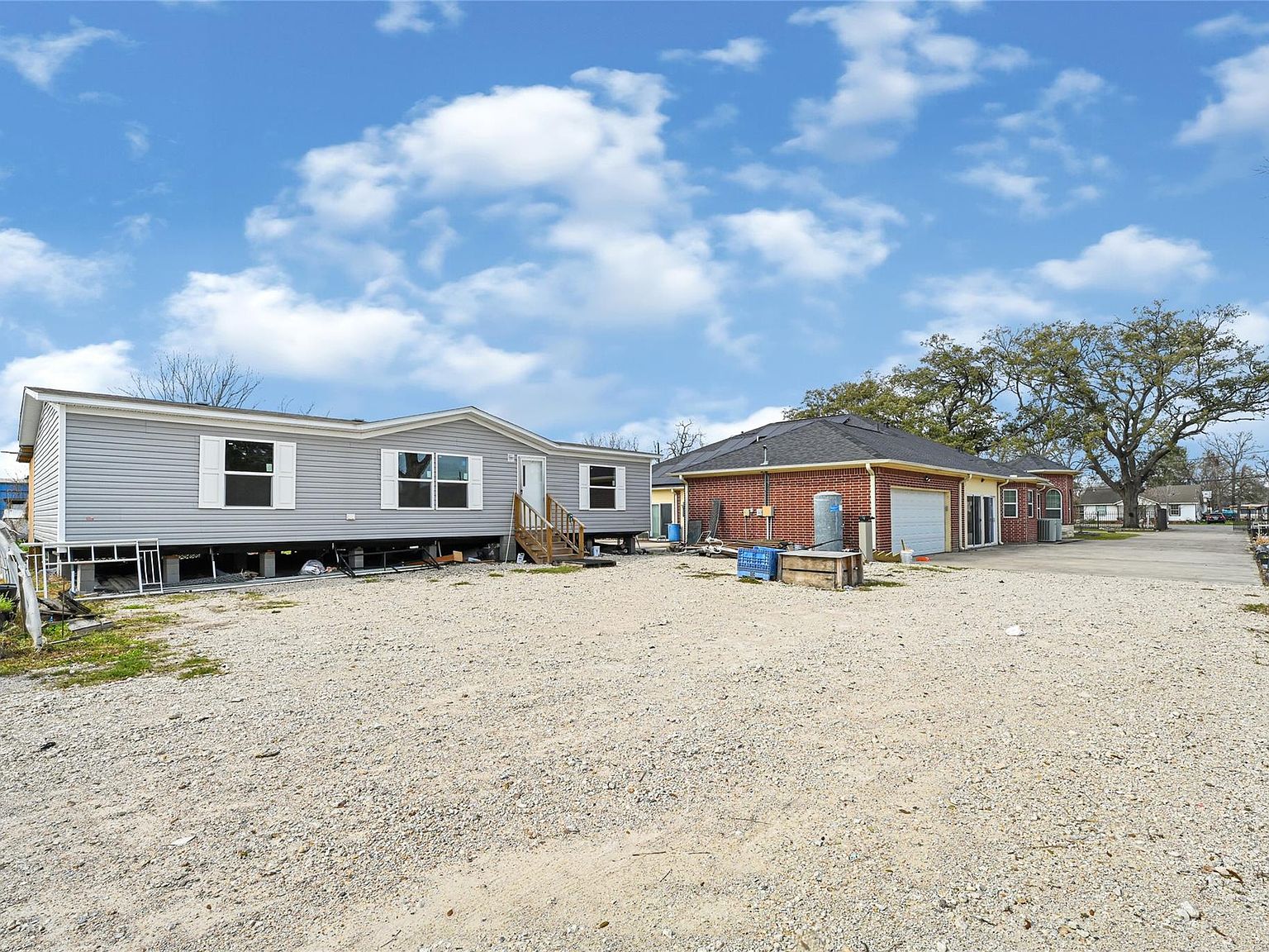 Rear of the property showing the separate mobile dwelling on the lot and the back of the brick estate, with open ground between them